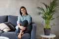 A young Woman is Sitting on the Sofa Looking at the Camera. The Girl Is Worried, Sad. Depression. Royalty Free Stock Photo