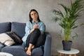 A young Woman is Sitting on the Sofa Looking at the Camera. The Girl Is Worried, Sad. Depression. Royalty Free Stock Photo