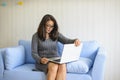 Young woman sitting on sofa and used laptop at home
