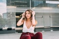 Young woman sitting in the stairs listening to music on the mobile phone Royalty Free Stock Photo