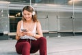 Young woman sitting in the stairs listening to music on the mobile phone Royalty Free Stock Photo