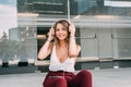 Young woman sitting in the stairs listening to music on the mobile phone Royalty Free Stock Photo