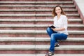 Young woman on stairs and making notes in notebook Royalty Free Stock Photo