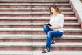 Young woman on stairs and making notes in notebook Royalty Free Stock Photo