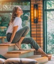 Young woman sitting on a stairs and posing. Cosy room in big house, interior design. Beauty model girl