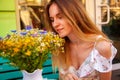 Young woman sitting at street cafe near flowers and green plants. Concept of cozy place in open air and resting. Royalty Free Stock Photo