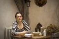 Young woman sitting at a table in the old cafe. Tryst.