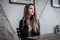 Young woman sitting at a table waiting Royalty Free Stock Photo