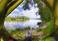 Young woman sitting in the tent while looking on the Desna river