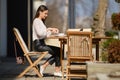 Young woman sitting on the terrace of the cafe in sunny day and eating cake Royalty Free Stock Photo