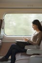 Young woman sitting on a train using her phone Royalty Free Stock Photo