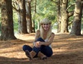 Young woman sitting between trees