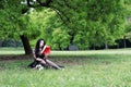 Read a book sitting under a blossom tree Royalty Free Stock Photo