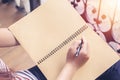 Young woman sitting on Vintage chair holding pen writing on paper and reading book Royalty Free Stock Photo