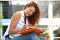 Young woman sitting and writing in book with pen Royalty Free Stock Photo
