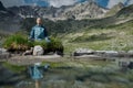 Young woman is sitting in yoga lotus position against the turquoise lake in the mountains Royalty Free Stock Photo