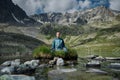 Young woman is sitting in yoga lotus position against the turquoise lake in the mountains Royalty Free Stock Photo