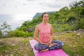 Young woman sitting on yoga mat in lotus pose, meditating, practicing yoga and pranayama. Deep breath and concentration. Bali, Royalty Free Stock Photo