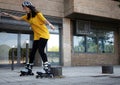 Young woman skating on the street dodging bollards