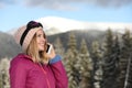 Young woman with ski goggles talking on phone in mountains during winter vacation Royalty Free Stock Photo