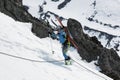 Young woman ski mountaineer climbing on rope on rocks