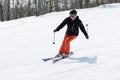 Young woman skier coming down the slope on sunny day Royalty Free Stock Photo