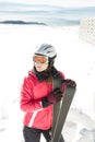 Young woman skier at winter ski resort in mountains, holding skies Royalty Free Stock Photo