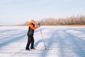 Young woman is skiing. Brunette in winter suit is doing sports in nature on background of forest, she is standing on