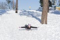 Young woman sledding in snow. laughing girl in winter clothing goes down on sleds down the hill Royalty Free Stock Photo