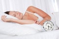 Young woman sleeping in bed with alarm clock Royalty Free Stock Photo