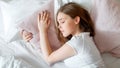 Young Woman sleeping in bed. Portrait of blonde teen girl have healthy good sleep on white pink pillow. Teenager girl in pajamas Royalty Free Stock Photo