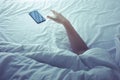 Young woman sleeping on bed with smartphone in morning. Royalty Free Stock Photo