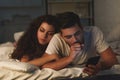 young woman sleeping and boyfriend with smartphone yawning Royalty Free Stock Photo