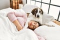 Young woman sleeping lying on bed with dog at bedroom Royalty Free Stock Photo