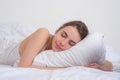 Young woman sleeping well in bed hugging soft white pillow. Girl resting, good night sleep. Woman sleeping. Beautiful Royalty Free Stock Photo