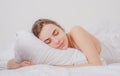 Young woman sleeping well in bed hugging soft white pillow. Girl resting, good night sleep. Woman sleeping. Beautiful Royalty Free Stock Photo