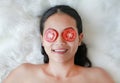 Young woman with a slice of tomato in her eye, concept for skin care Royalty Free Stock Photo