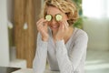 Young woman with slices cucumber on eyes