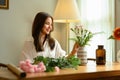 Young woman small business owner preparing bouquet of pink flowers at tablet in her flower shop Royalty Free Stock Photo