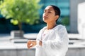 Young woman with smart watch breathing outdoors