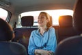 Woman with phone on the back seat of a car Royalty Free Stock Photo