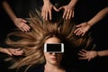 Young woman with smartphone  her eyes surrouded by people`s hands on black background, top view. Space for text Royalty Free Stock Photo