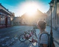 Young woman with a smartphone in her hands on the street in a European city, vintage building and parked bicycles