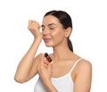 Young woman smelling essential oil on wrist against white background Royalty Free Stock Photo