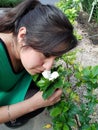 young woman smelling a flower of gardenia
