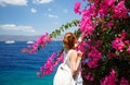 Young Woman Smelling Flowers In Hydra Island, Greece. Mediterranean. Blue Sky