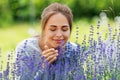 Young woman smelling lavender flowers in garden Royalty Free Stock Photo
