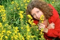 Young woman smelling yellow flowers