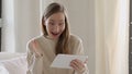 Young woman smiles after receiving good news on her tablet computer while lying on the bed Royalty Free Stock Photo