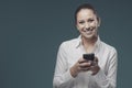 Smiling young woman connecting with her smartphone